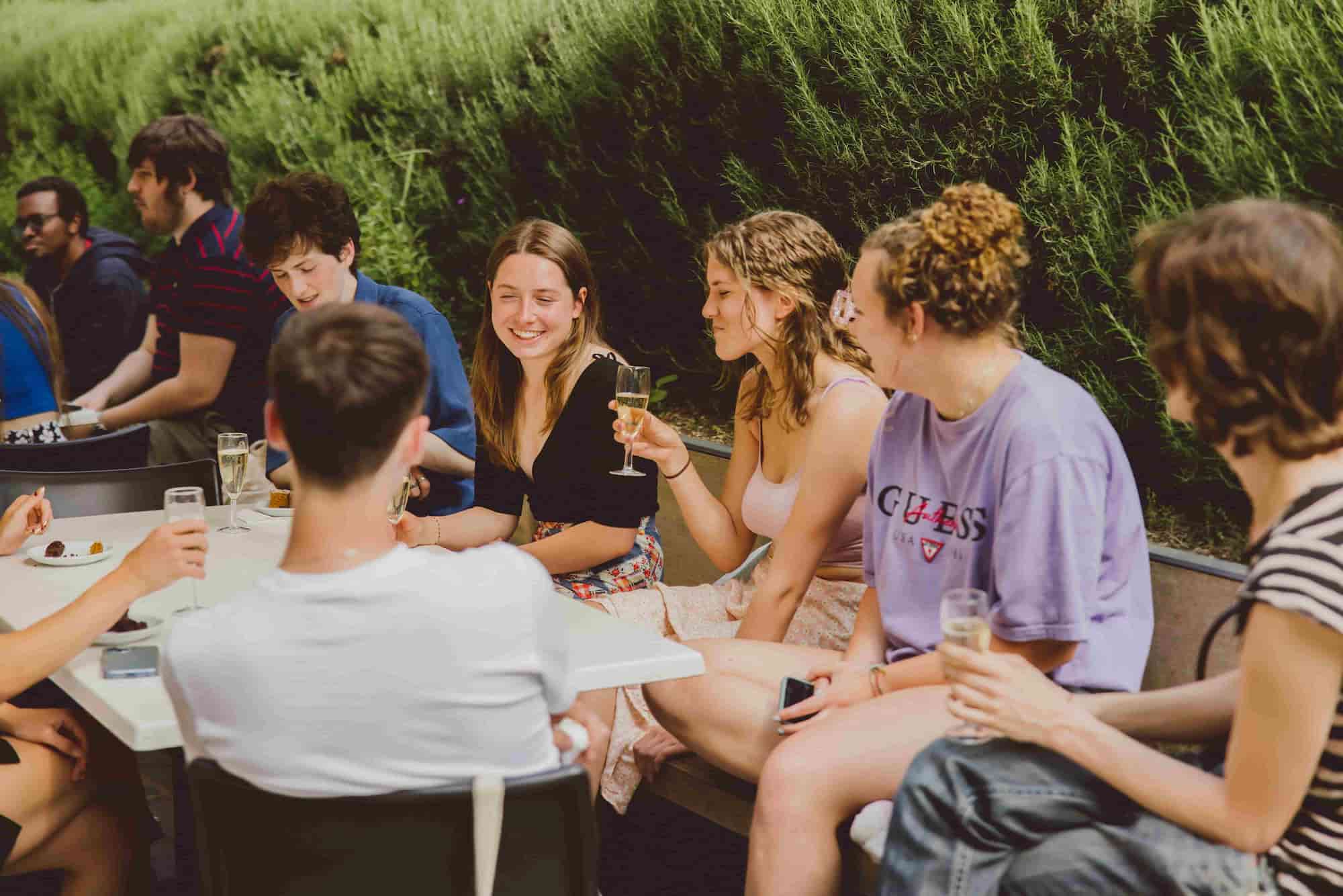 Photo of students celebrating in the Crypt outdoor seating.