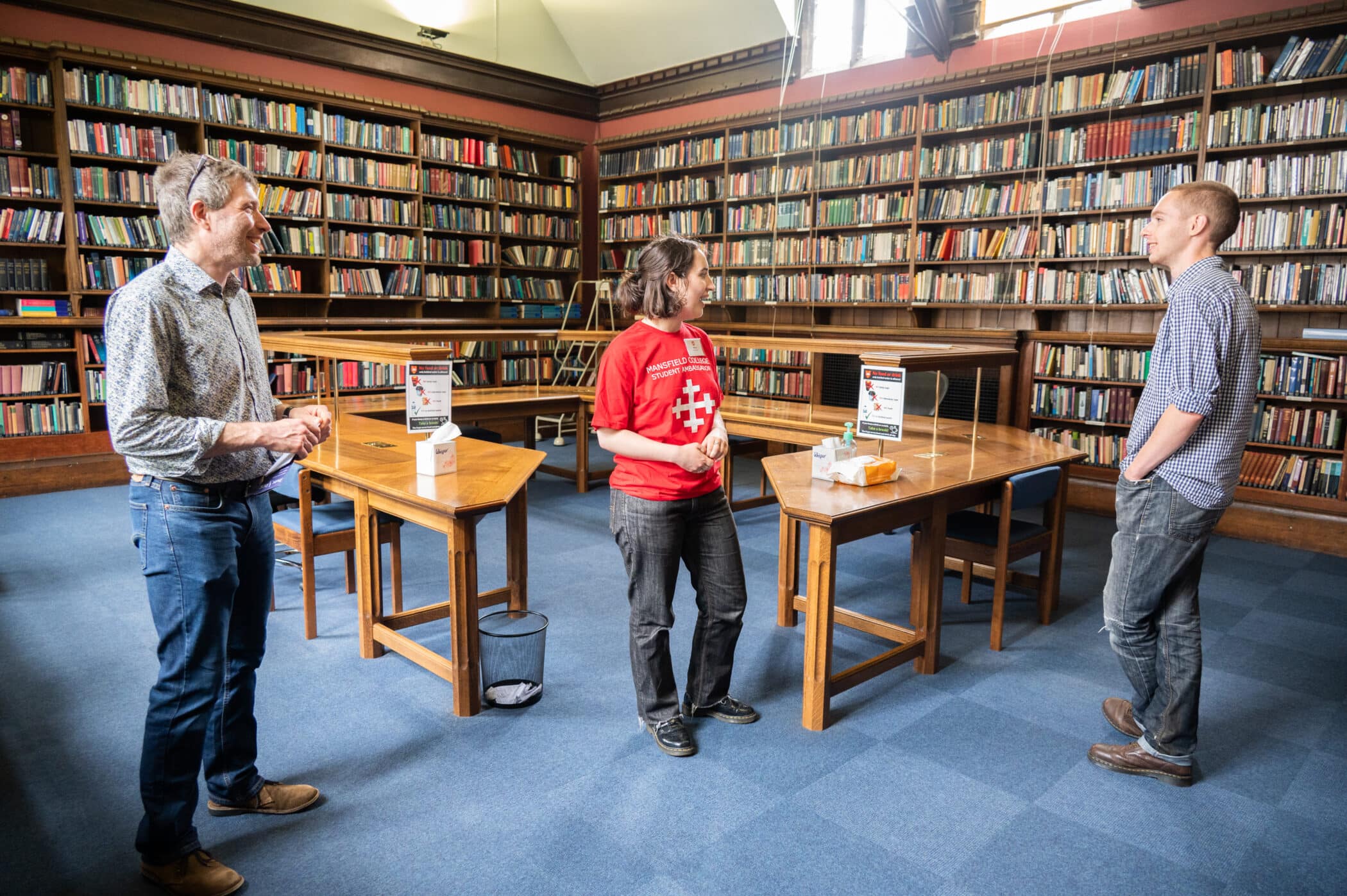 Student ambassador showing two people the Theology Reading Room (Library)