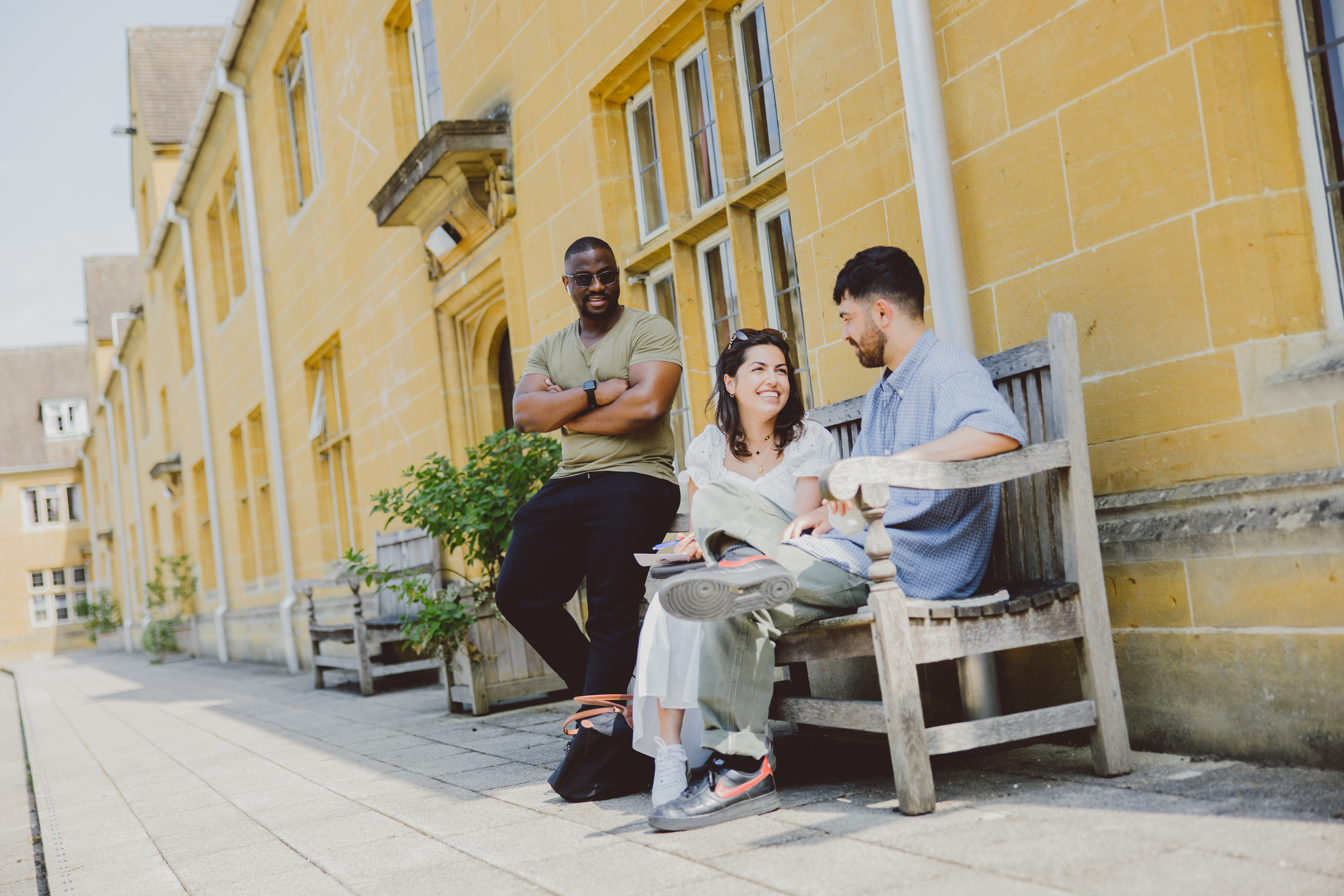 Students talking on a bench outside the John Marsh Building.