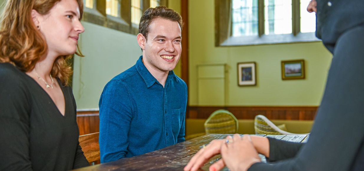Students talking at a table in the MCR.