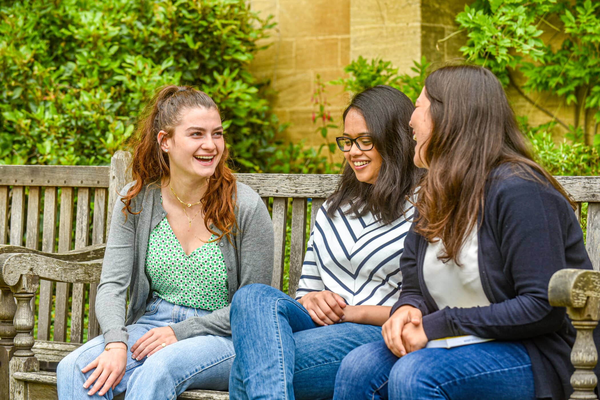 Students talking on a bench.