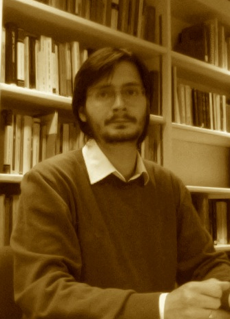 Photo of Andrei with bookshelves behind him