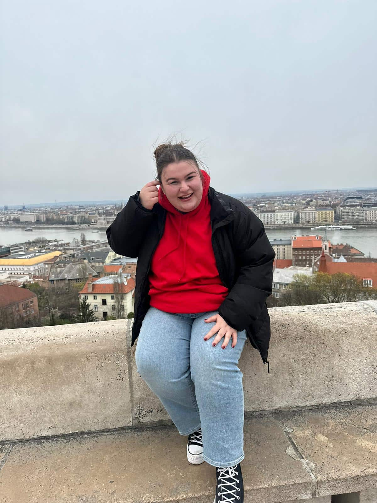 Photo of Amelia perched on the edge of a short wall