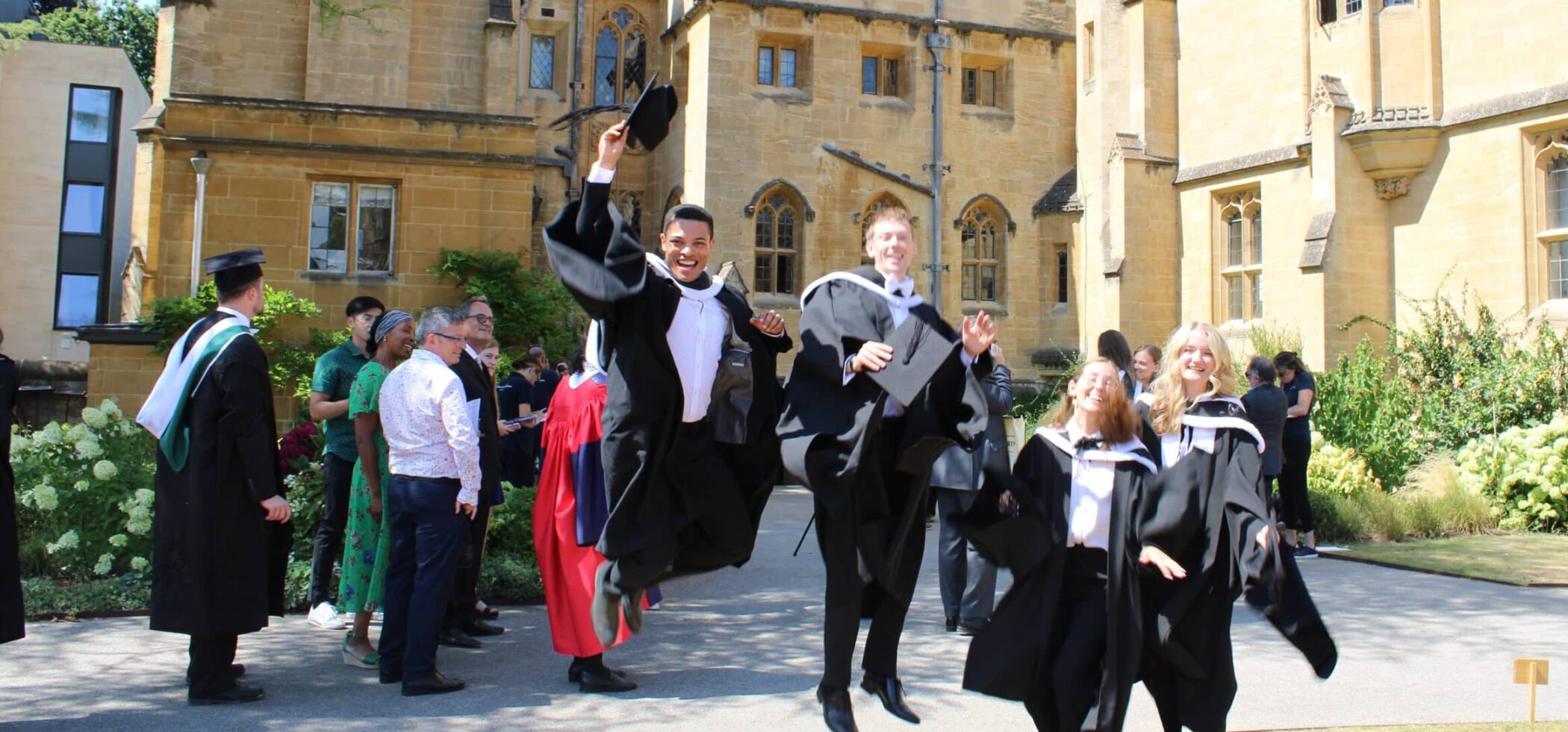 students in graduation gowns jumping in the air