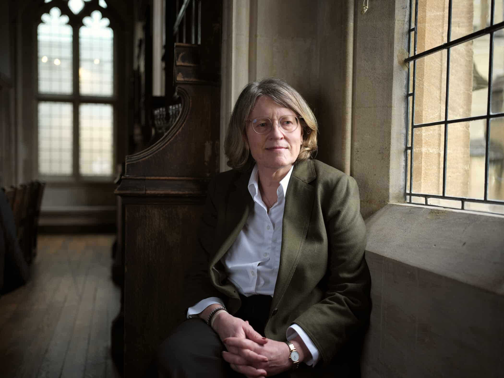 Photo of Helen Margetts sat by window.