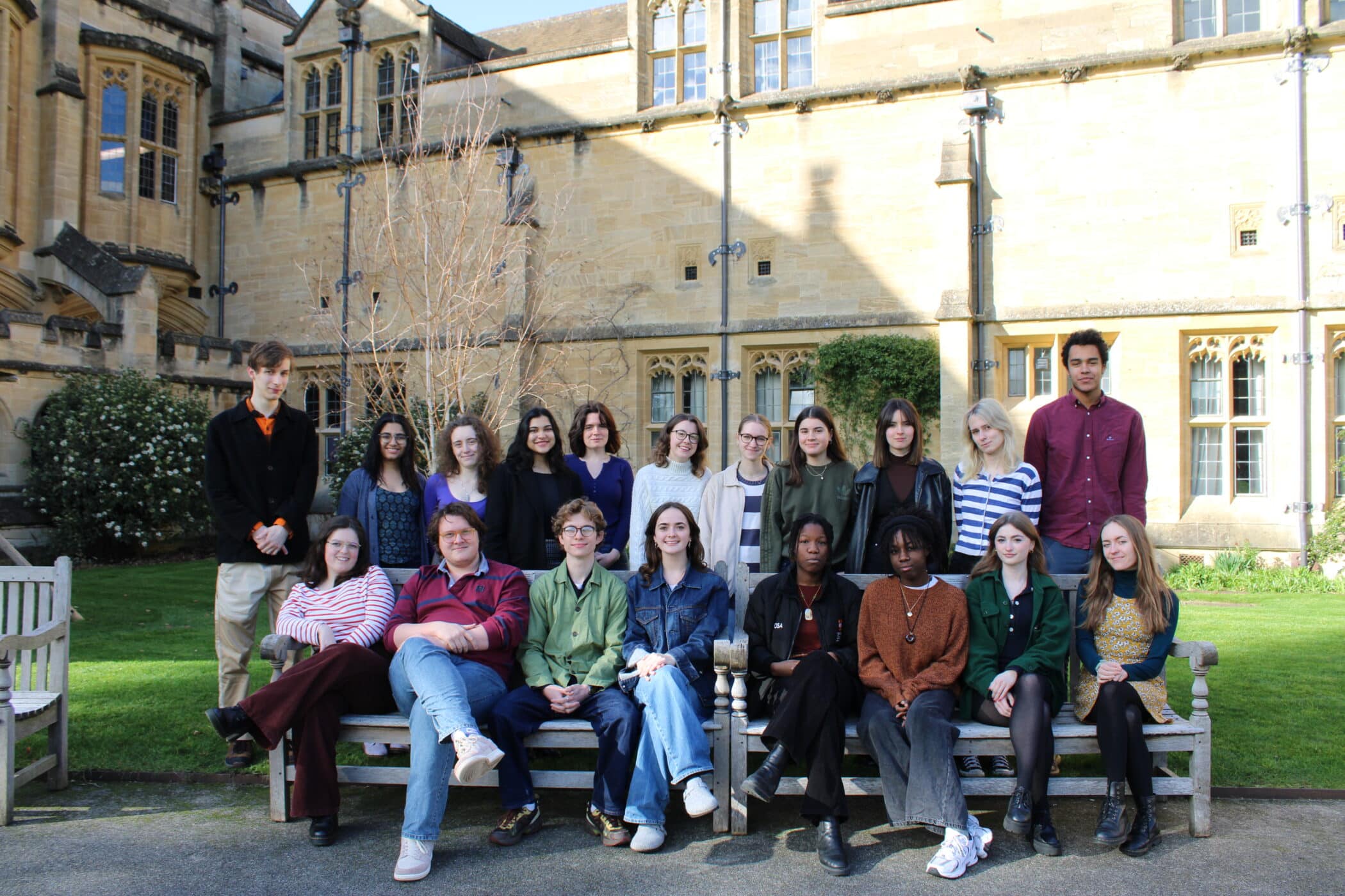 Group photo of students, some sat on the bench and some standing behind