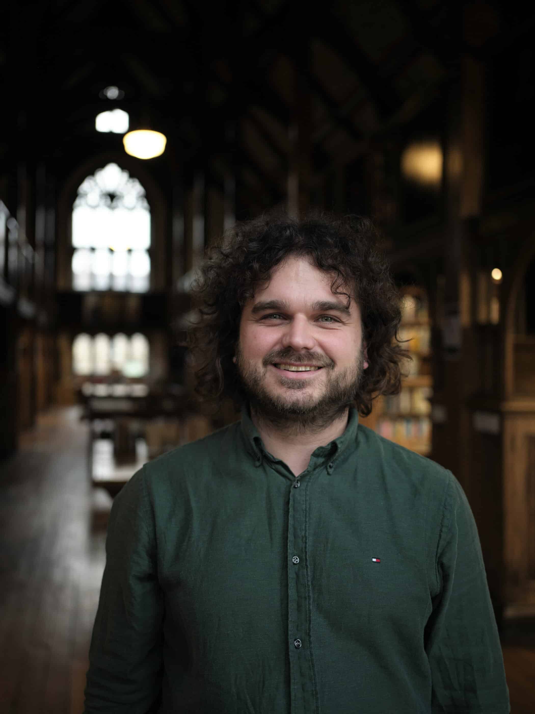 headshot of Mark Hughes in the library