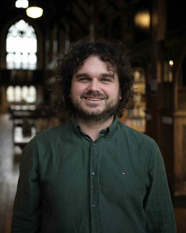 headshot of Mark Hughes in the library