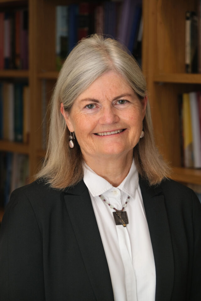 Headshot of Katherine O'Regan with bookshelves behind