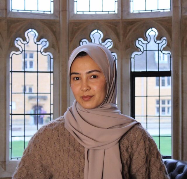 Photo of Shukria Rezaei with arched windows overlooking Mansfield quad