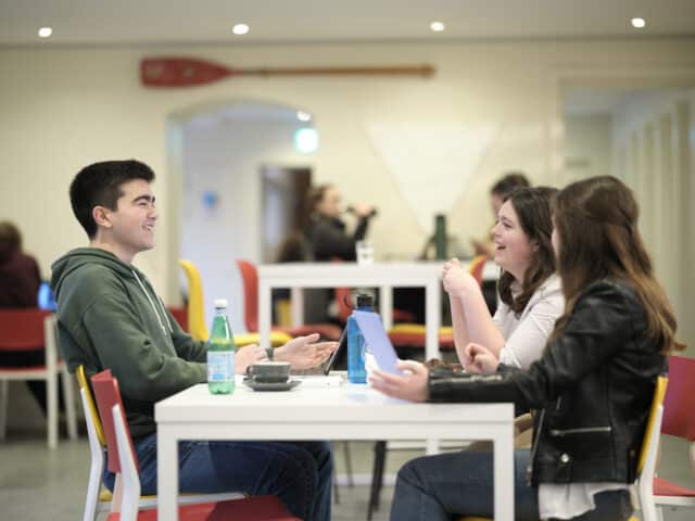 students around a table in the crypt cafe chatting