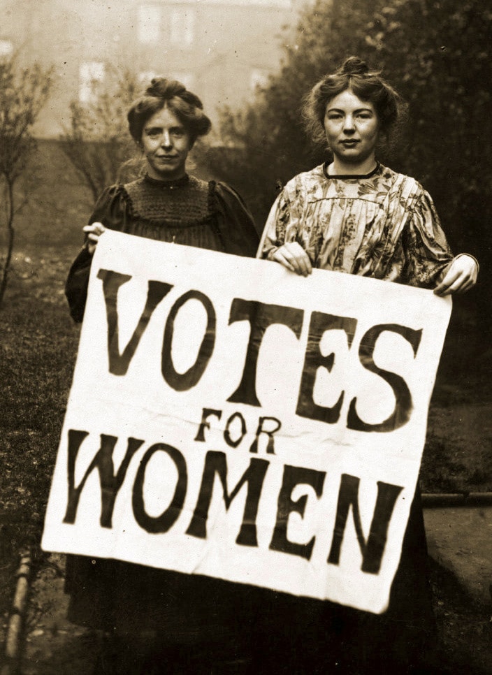 A photograph of Annie Kenney and Christabel Pankhurst holding a Votes for Women sign.